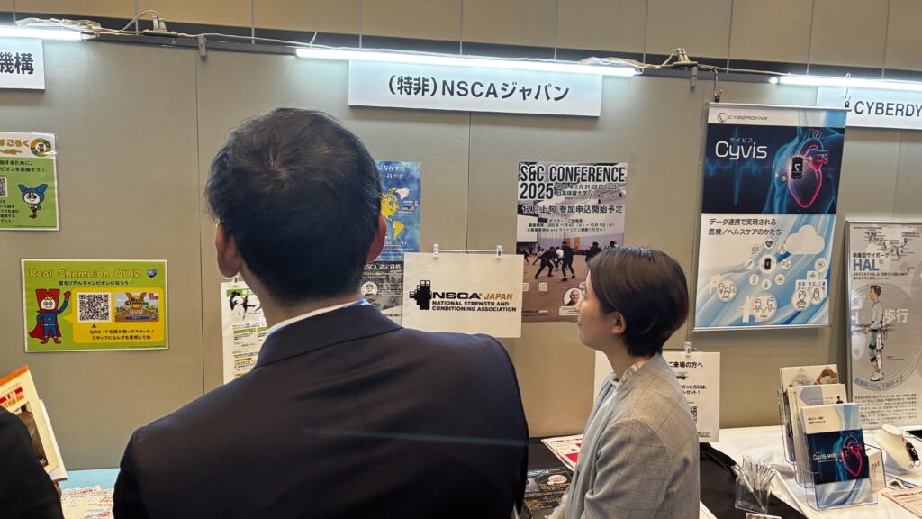 NSCAジャパンのブースで話を聞く人