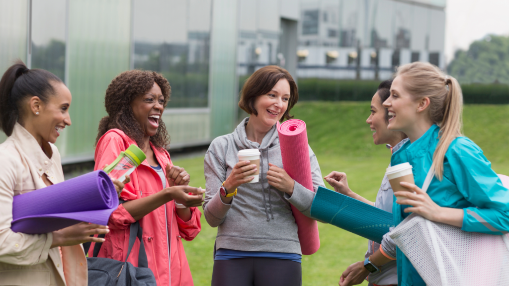 トレーニング用品を持ちながら談笑している女性たち
