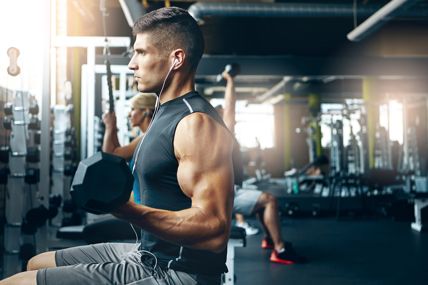 ジムで音楽を聴きながらトレーニングする人々