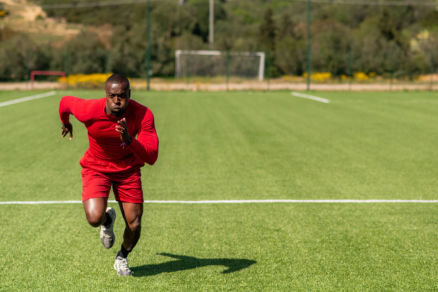 サッカーコートで走っている男性