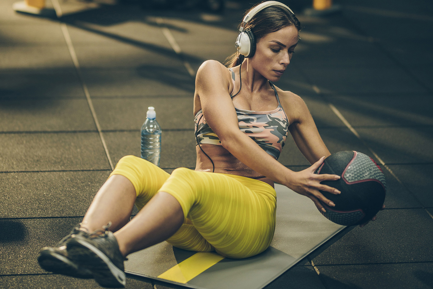 音楽を聴きながらボールを使ったトレーニングをしている女性