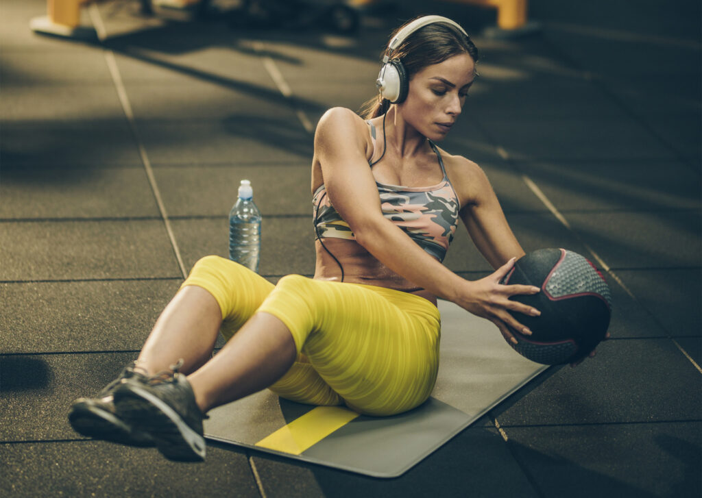 音楽を聴きながらボールを使ったトレーニングをしている女性